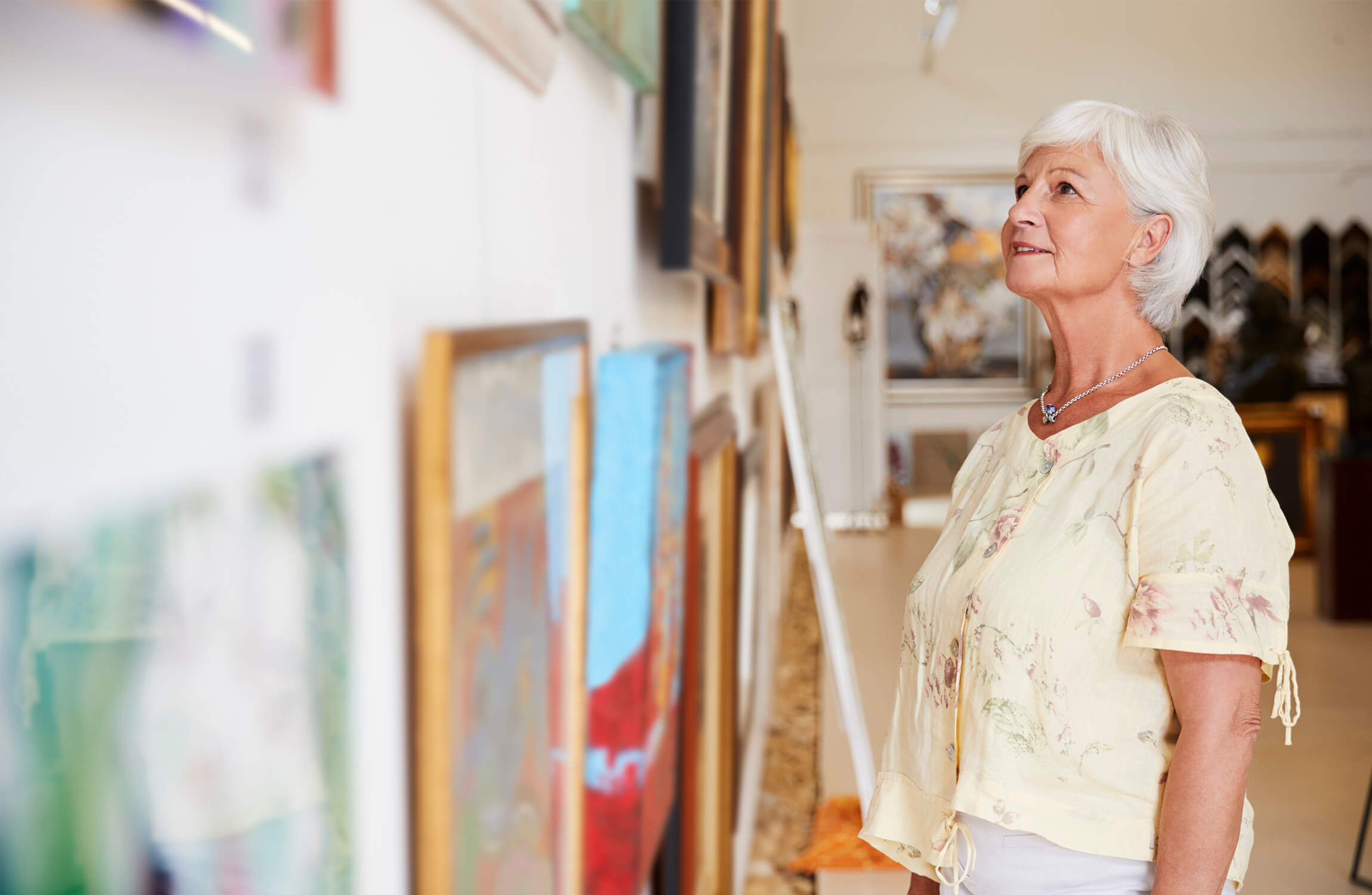 Senior woman walking around art gallery