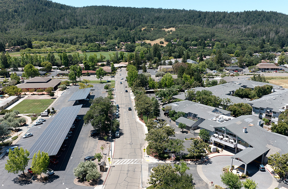 Aerial view of senior living community with tree-lined roads and multiple units.