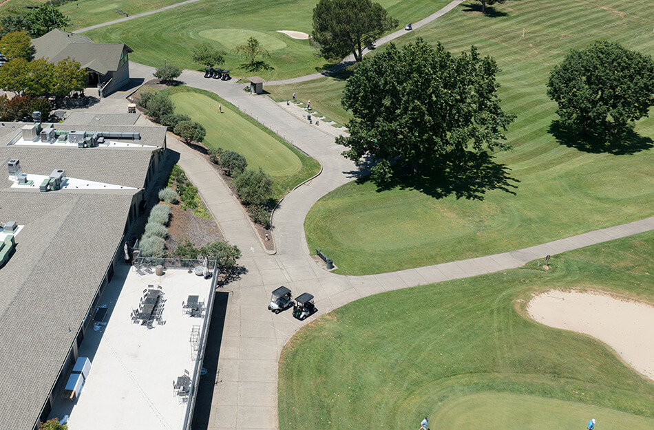 Aerial view of units near a landscaped golf course with trees and pathways.